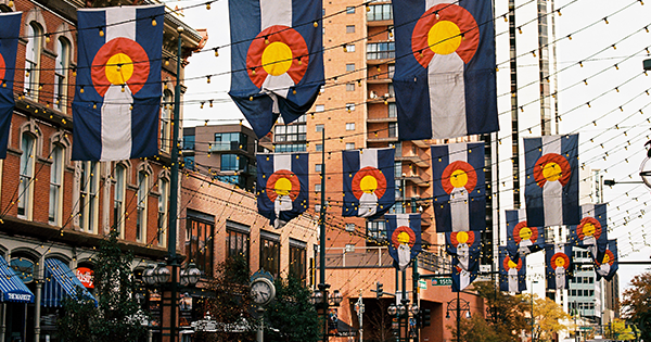 Colorado state flags hanging over a city street